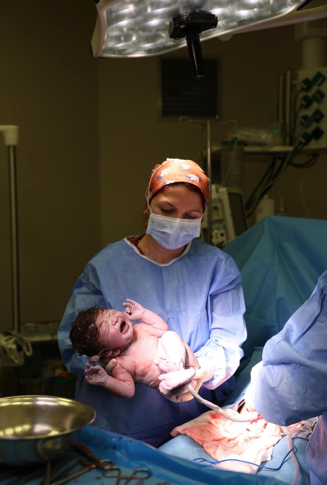 Operasyon sırasında yenidoğanın hekim tarafından tutulduğu klinik fotoğraf